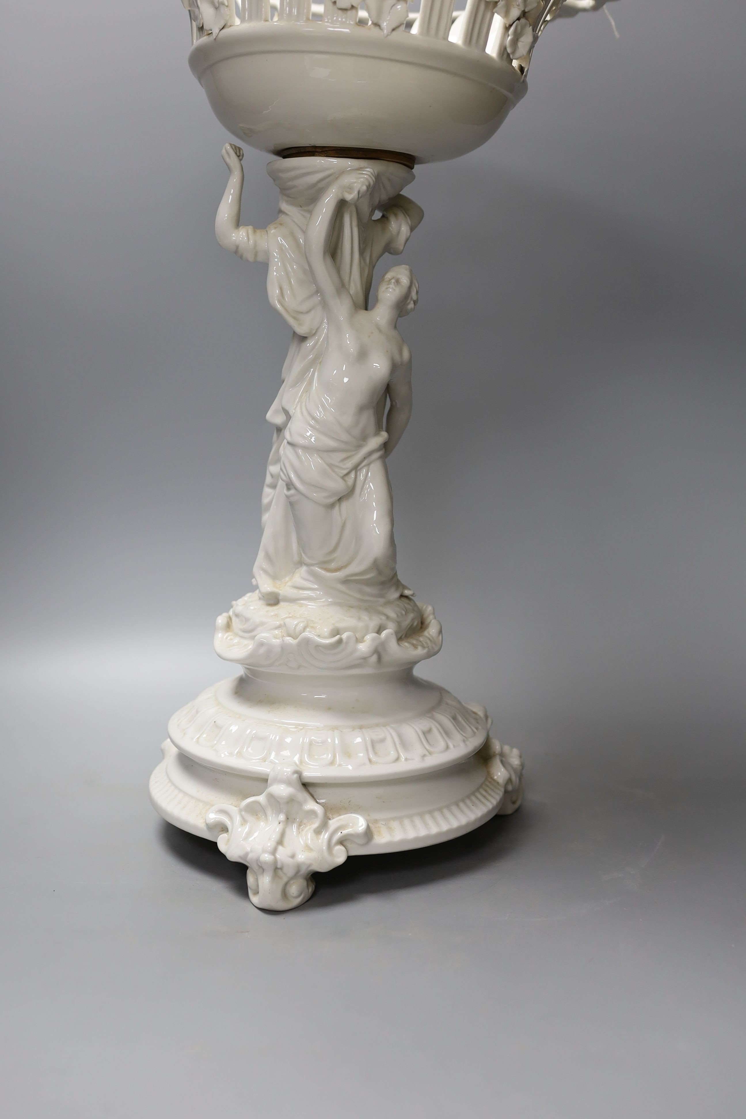 A Continental white glazed porcelain centrepiece bowl modelled with two maidens - 47cm tall